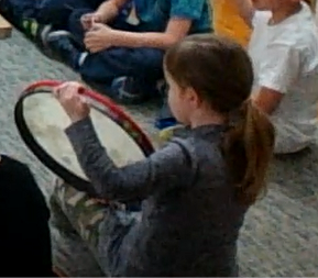 First grade student engaging in a rhythm activity on the hand drum